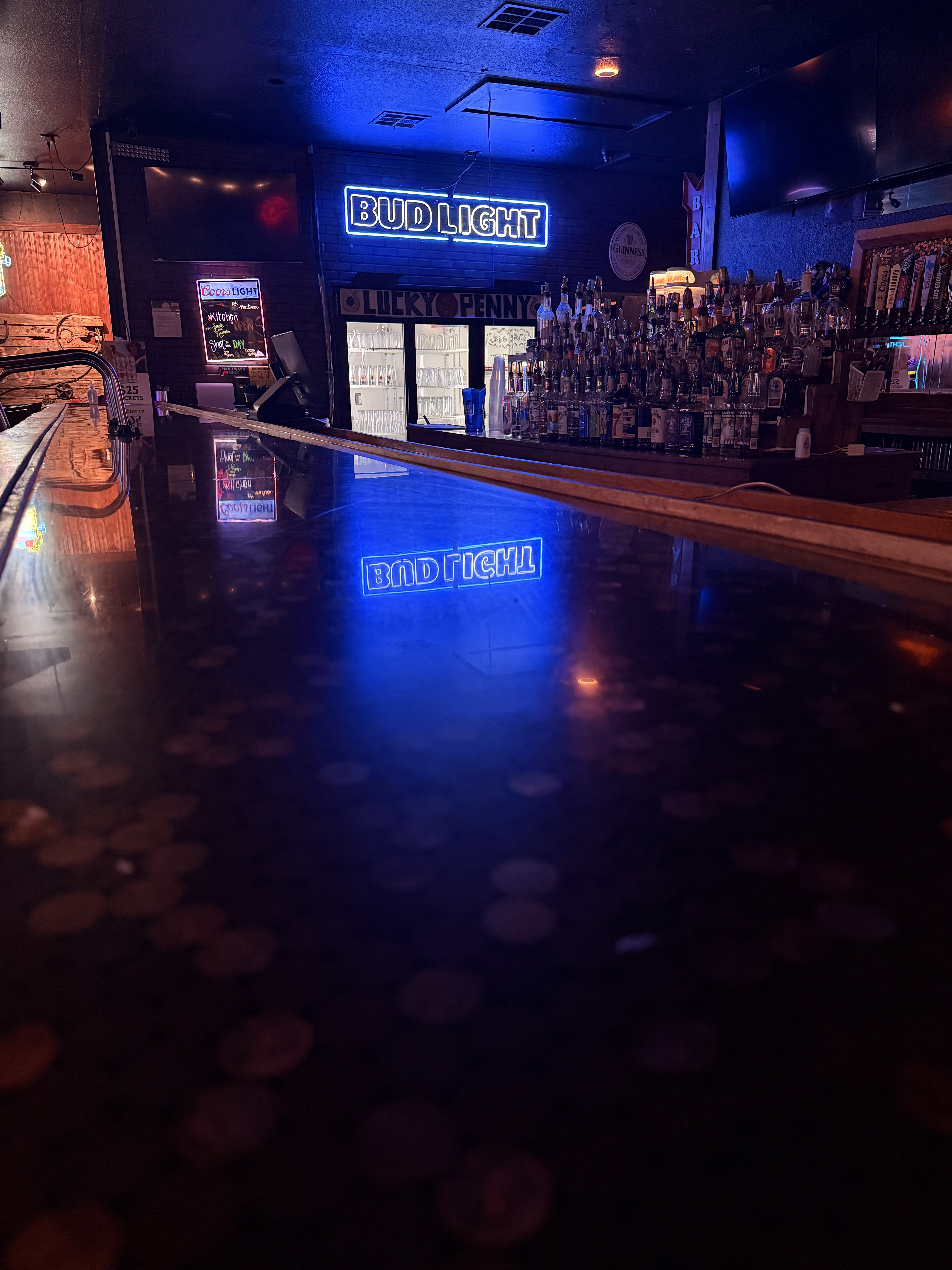 Warmly lit bar interior with copper pennies embedded in the wooden counter